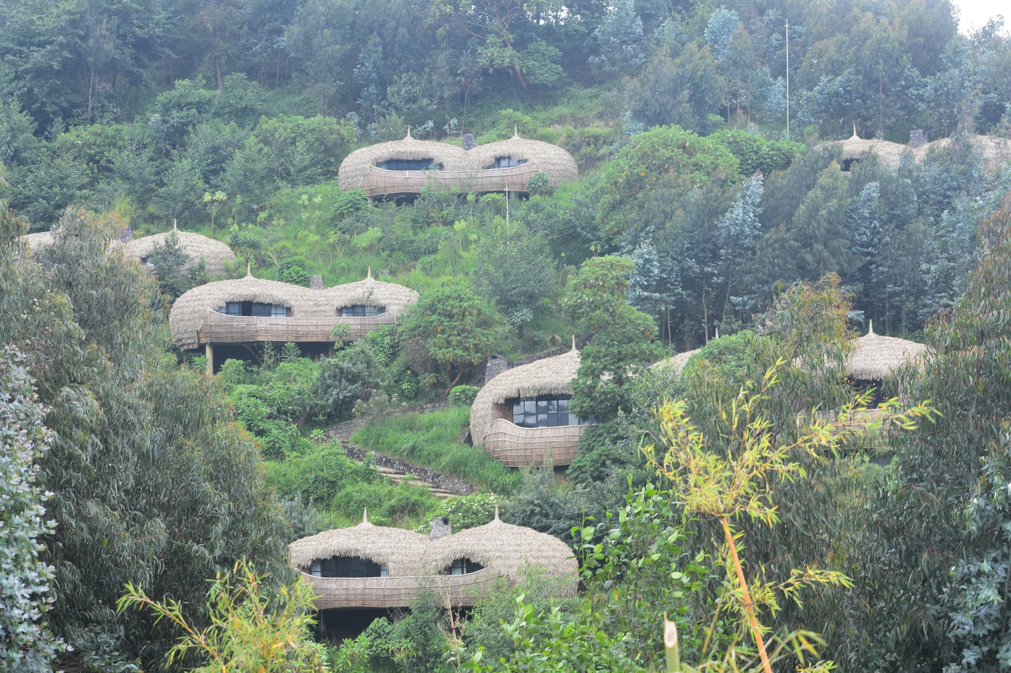 Volcanoes National Park, Rwanda — a cluster of stone forest suites at the foot of the volcanoes